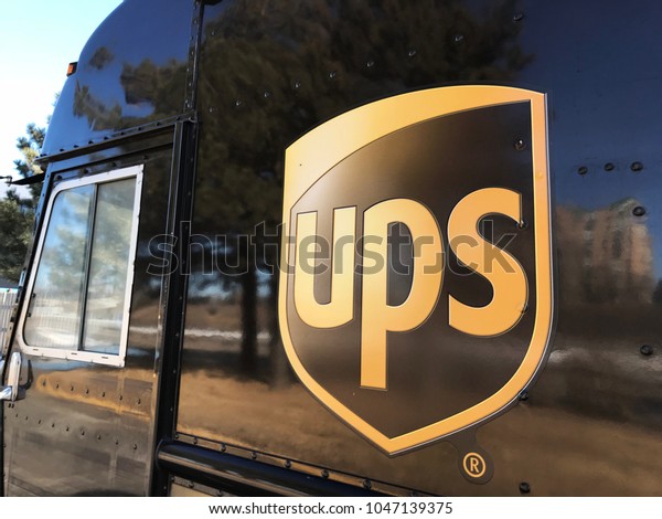 Minneapolis, MN/USA- March 15, 2018. The side of\
a UPS delivery truck parked at a building as the driver makes\
deliveries. The United Parcel Service is a multinational package\
delivery company.