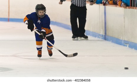 Minor Ice Hockey Child Skating After The Puck During A Game