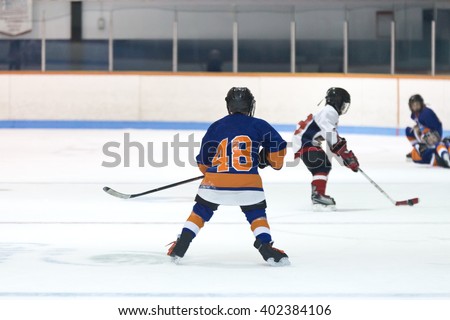 Minor ice hockey game action with kids