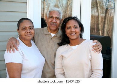 Minority family standing outside their new home