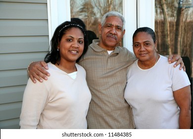 Minority family standing outside their new home
