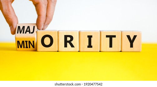 Minority Or Majority Symbol. Businessman Turns A Cube And Changes The Word 'minority' To 'majority'. Beautiful Yellow Table, White Background. Minority Or Majority And Business Concept. Copy Space.