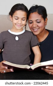 Minority Woman And Her Daughter Reading The Bible