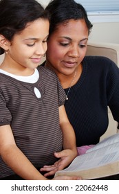 Minority Woman And Her Daughter Reading The Bible