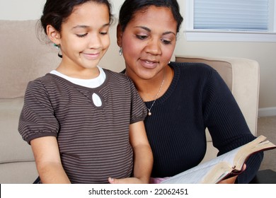 Minority Woman And Her Daughter Reading The Bible