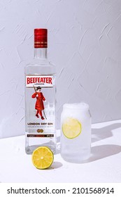 Minsk, Belarus - 04-01-2022: Making Gin And Tonic Cocktail With Beefeater London Dry Gin. A Highball Glass With Ice Cubes And Lime.