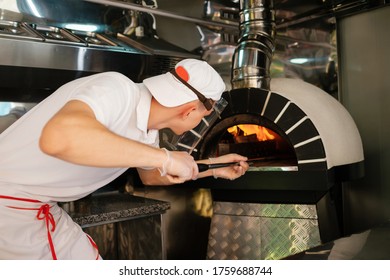 Minsk / Belarus - 06 10 2020: The Process Of Making Pizza. Italian Pizza In Wood Stove. Italian Pizza Is Cooked In A Wood-fired Oven.