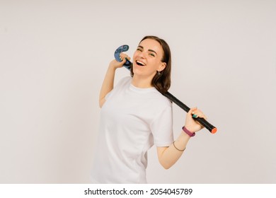 Minsk, Belarus - 06.24.2021. Beautiful young woman holding a floorball hockey stick against white background