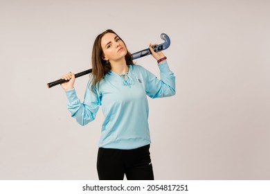 Minsk, Belarus - 06.24.2021. Beautiful young woman holding a floorball hockey stick against white background