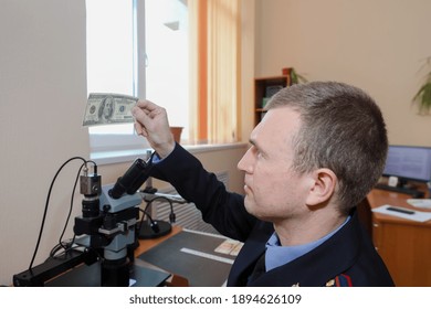 MINSK, BELARUS - 1 OCTOBER, 2020: Criminologist Examines Counterfeit Bills