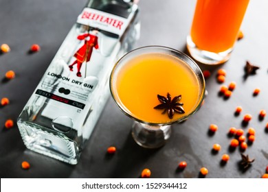 Minsk, Belarus, 10-10-2018. An orange Beefeater gin drink in a cocktail glass with anise and sea-buckthorn liqueur