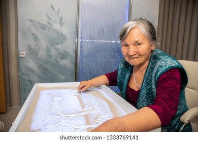MINSK, BELARUS - 18 FEBRUARY, 2019: old woman sand painting
