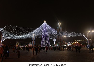 Minsk. Belarus. 27 december 2020. View of a New Year's festive tree decorated with bright lights at night. Beautiful decoration of the city for Christmas.