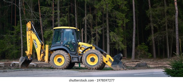 Minsk, Belarus. Apr 2021. Tractor JCB 4CX parked on construction site in the forest. Yellow JCB tractor, excavator - heavy duty equipment vehicle.