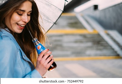MINSK, BELARUS - APRIL, 2017: Happy Woman With Ubrella Drinking Pepsi