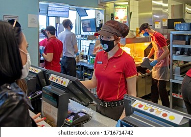 MINSK, BELARUS - April 27, 2020: Workers In Medical Masks Serve Customers At McDonald's Restaurant During A Coronavirus Epidemic. Lifestyle During Pandemic.