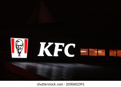 Minsk, Belarus. Aug 2021. KFC Restaurant Glowing Sign At Night. KFC Signboard On Facade Wall Of Building. Kentucky Fried Chicken Restaurant Sign, American Fast Food Chain, Colonel Sanders Logo