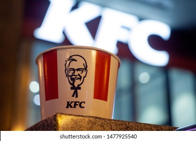 Minsk, Belarus - august 10, 2019: KFC bucket on background of a restaurant sign in night light.
