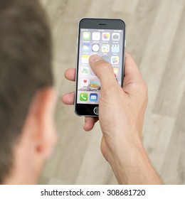 Minsk, Belarus - August 15, 2015: IPhone 6 In The Man Hand. The Operating System IOS. The Founders: Steve Jobs, Steve Wozniak, Ronald Wayne. Apple Inc. Located In USA