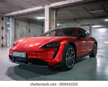 Minsk, Belarus - August 25, 2021: Porsche Taycan Sport Turismo in the underground parking. The car is covered with raindrops. This model is a more practical alternative to the Taycan electric car.