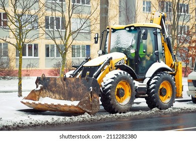 Minsk, Belarus. Dec 2021. JCB tractor backhoe 4CX parked at roadside in the city. Yellow JCB tractor, excavator - heavy duty equipment vehicle, ready remove snow and clean street in winter season.