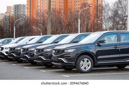 Minsk, Belarus. Dec 2021. New car Geely Atlas parked in row outdoors, brand new cars for sale. Chinese crossover, SUV car Geely Atlas cars for sale. Parking lot of an authorized dealership Geely