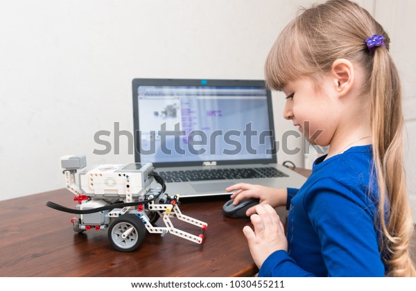 Minsk, Belarus.\
December, 2017. STEM education. Little girl programmes Lego\
Mindstorms EV 3 Robot on Scratch. Battle. Robotics class for child\
and teen. School.  Mathematics.\
