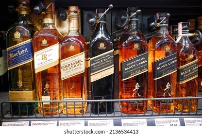 Minsk, Belarus. Feb 2022. Johnnie Walker Blue Label, Gold Label, Double Black Label - bottles of popular blended scotch whisky on supermarket shelf, Selective Focus. Johnnie Walker assortment