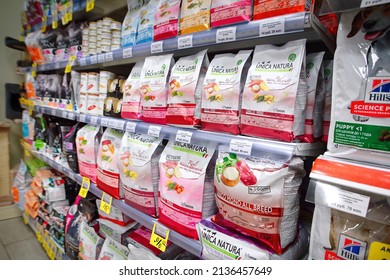 Minsk, Belarus. Feb 2022. Pet food Unica Natura Italy brand on display at pet store. Dog and cat food products at supermarket shelf. Dry and wet cat and dog food aisle at pet supply shop