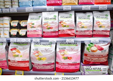 Minsk, Belarus. Feb 2022. Pet food Unica Natura Italy brand on display at pet store. Dog and cat food products at supermarket shelf. Dry and wet cat and dog food aisle at pet supply shop