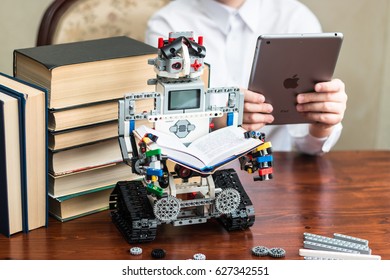 Minsk, Belarus -  February 11, 2017: Lego Robot Reading A Book. Teenager Read The Book On Ipad Apple. School. E-learning.  STEM Education.