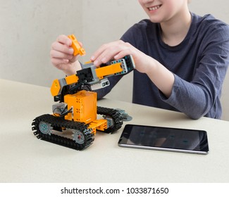 Minsk, Belarus. February, 2018. Teenager Child Schoolboy Programmes Ubtech Jimu Robot On Ipad Apple. Robot For STEM Education At The Classroom. Code The Bot. Robotics. Progressive American Education. 