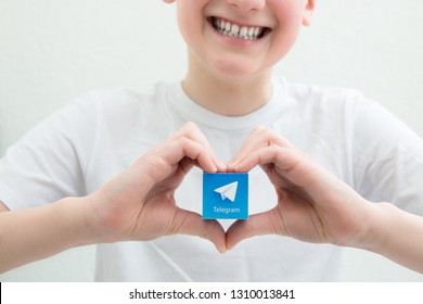 Minsk, Belarus. February, 2019. Teenager Boy Holds Social Network Telegram Logo In His Hand. White Background.