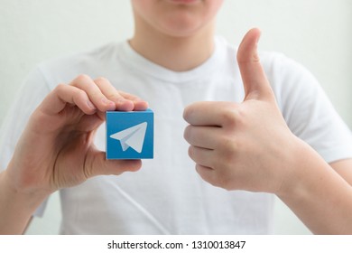 Minsk, Belarus. February, 2019. Teenager Boy Holds Social Network Telegram Logo In His Hand. White Background.