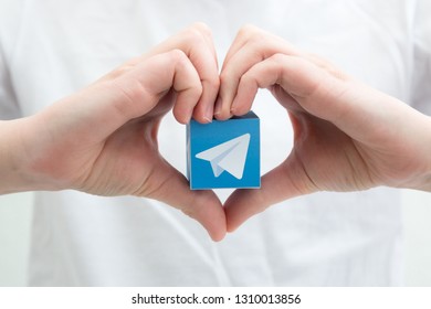 Minsk, Belarus. February, 2019. Teenager Boy Holds Social Network Telegram Logo In His Hand. White Background.