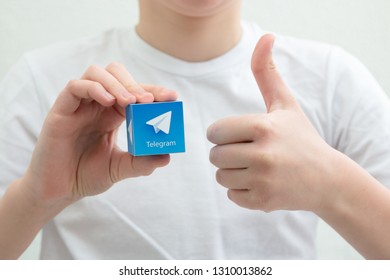 Minsk, Belarus. February, 2019. Teenager Boy Holds Social Network Telegram Logo In His Hand. White Background.