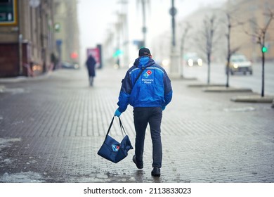 Minsk, Belarus. Jan 2021. Domino's Pizza Delivery Courier, Boy With Thermal Bag Delivering Food In Winter Day. Food Dlivery Service, Man Deliver Pizza In Foggy Day. Dominos Pizzeria Takeaway Service