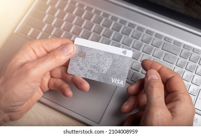 Minsk, Belarus - January 10, 2022 Paying online with bank card Visa and laptop close up. Internet payment concept.