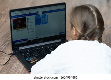 Minsk, Belarus. January, 2020. The BBC robot Micro Bit is connected to a computer. A cute little girl is programming it on Scratch and Python. Creative. Connected. Coding. Learning, teaching easy.