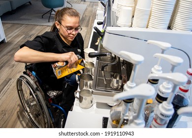 MINSK, BELARUS - January, 2021: Wheelchair Disabled Person Works As A Barista In An Inclusive Coffee Shop. The Barista Prepares Coffee In His Cafe At Work. A Unique Project, An Inclusive Coffee Shop