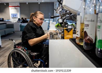 MINSK, BELARUS - January, 2021: Wheelchair Disabled Person Works As A Barista In An Inclusive Coffee Shop. The Barista Prepares Coffee In His Cafe At Work. A Unique Project, An Inclusive Coffee Shop