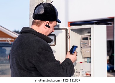 Minsk. Belarus. January 23, 2019. The Owner Of The House Is Checking The Electricity Meter On The Street. Winter, A Lot Of Snow