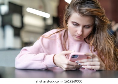 MINSK, BELARUS - JANYARY, 2020: Pretty Girl Using Iphone 11 In The Cafe.