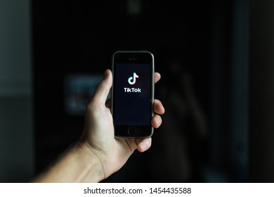 Minsk, Belarus - July 18, 2019: Tik Tok app icon on Apple iPhone screen closeup in man's hands. Social networking icon - Shutterstock ID 1454435588