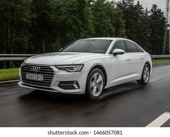 MINSK, BELARUS - JULY 28, 2019: Audi A6 45 TFSI Quattro 2019 model year drives on a wet asphalt road during test drive event. The car equipped with 2-litre turbo engine producing 252 hp.
