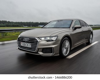 MINSK, BELARUS - JULY 28, 2019: Audi A6 55 TFSI Quattro 2019 model year drives on a wet asphalt road during test drive event. The car equipped with 3-litre V6 turbo producing 340 hp.