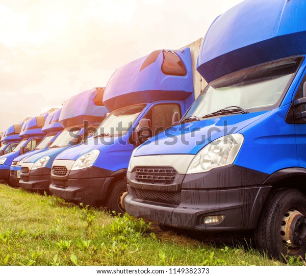 MINSK,\
BELARUS - JULY 3, 2018: Blue cargo vans stand in a row, trucking\
and long-distance, trucking industry and\
sun