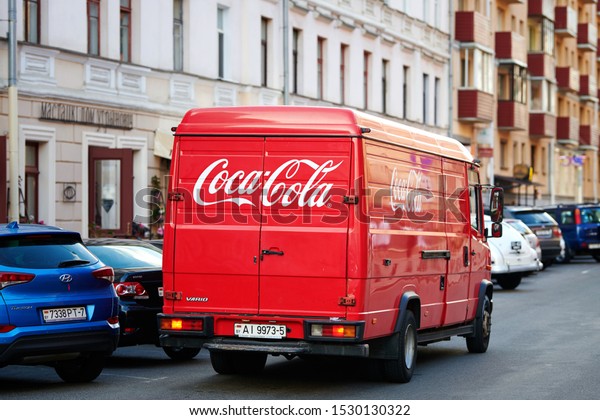 Minsk, Belarus - June 2019. Coca Cola branded van\
riding on road through the center of old city. Food and Drinks\
delivery from distributor to restaurants. Mercedes-Benz Vario, red\
Coca-Cola truck