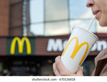 Minsk, Belarus, june 23, 2017: McDonald's soft drink. Woman drinks a drink in the background of the McDonald's restaurant