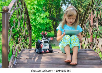 Minsk, Belarus - May, 2018: Little Girl Programs Lego Robot Mindstorms EV3 On IPad Apple. Stem Education. E-learning. Elementary School In The Garden. Robotic Class. Lesson. AI. Code Bot.